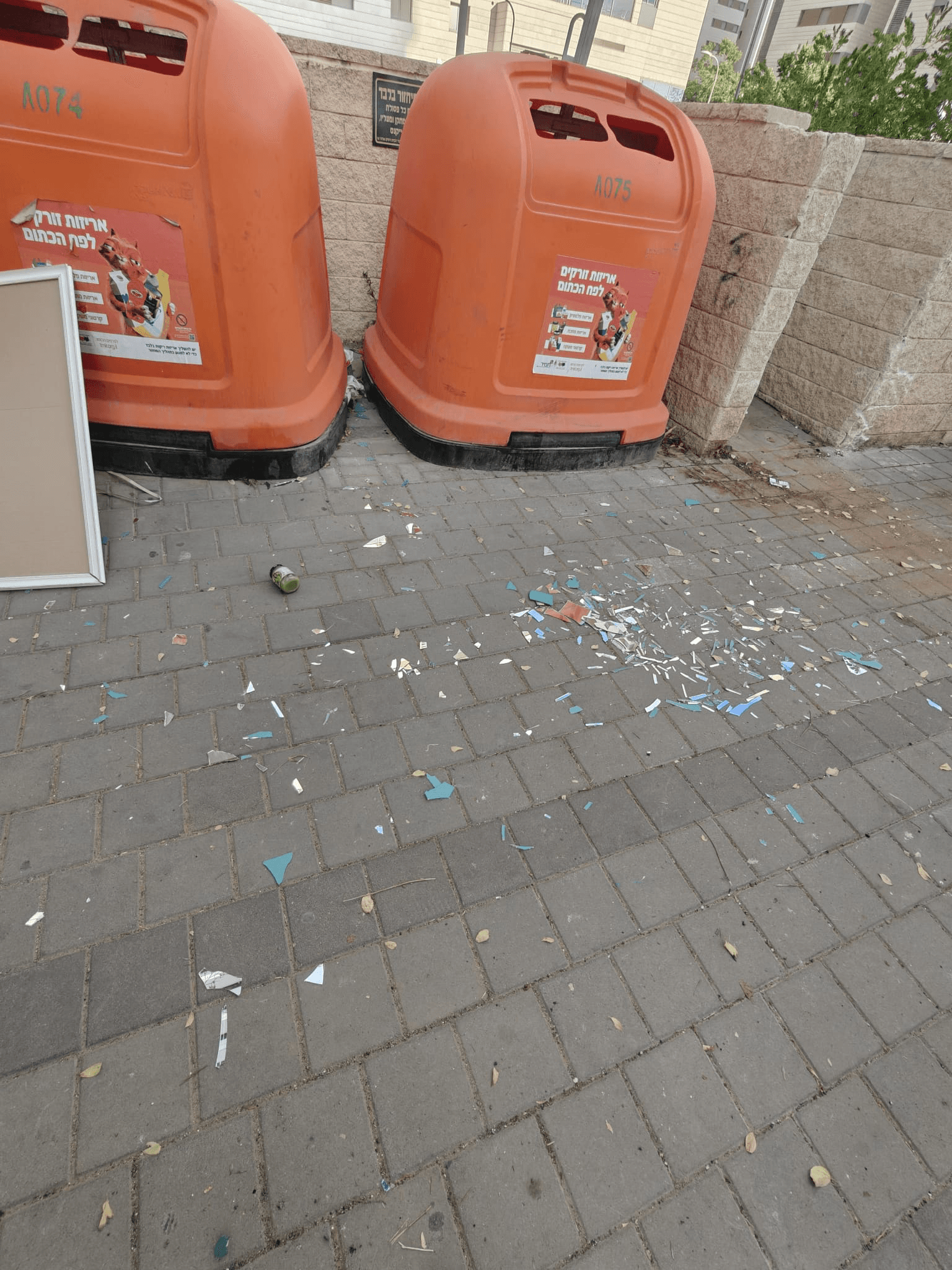 זבל מפוזר מסביב לפחי הזבל הכתומים